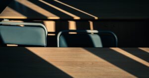 人物のいない教室の机に差し込む光を背景に、安城東高校の2027年度入試と5教科対策を考えるイメージ