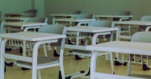 人物のいない教室を背景に、第五商業高校のビジネス科と2027年度入試を考えるイメージ