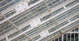 人物のいない明るい農業用温室の屋根を背景に、羽生実業高校の4学科と2027年度入試を考えるイメージ