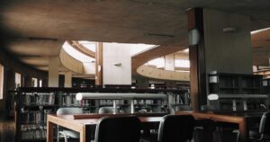 人物のいない学校図書館の机と本棚、尽誠学園高校の普通科4コースと衛生看護科を解説する横長サムネイル