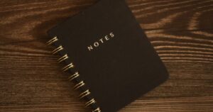 人物のいないノートと木製机を背景に、甲斐清和高校の4コース・音楽科と2027年度入試を考える記事サムネイル