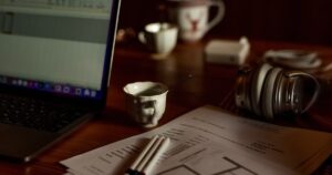 人物のいないノートパソコン・書類・筆記具の学習机を背景に、開志国際高校の2027年度入試と4コースを考えるイメージ