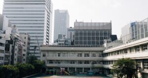 校舎を背景に金沢学院大学附属高校の4コースと入試準備を考えるイメージ