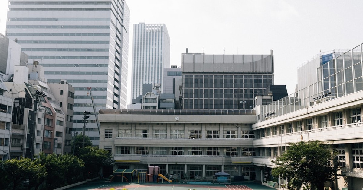 校舎を背景に金沢学院大学附属高校の4コースと入試準備を考えるイメージ