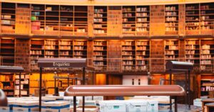 人物のいない図書館の机と本を背景に、金沢泉丘高校の普通科・理数科と2027年度入試を考えるイメージ