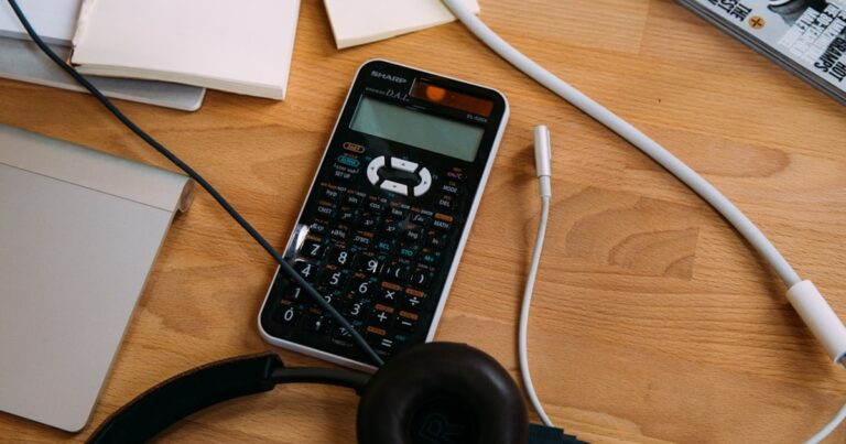 人物のいない机上のノートパソコン・電卓・ノートで熊本商業高校の商業学習と入試対策を表す写真