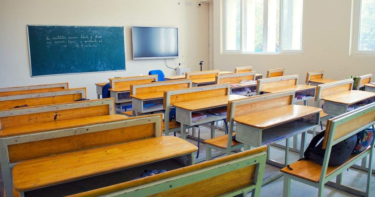 人物のいない明るい高校の図書室を背景に、共栄学園高校の5コースと2027年度入試を考えるイメージ