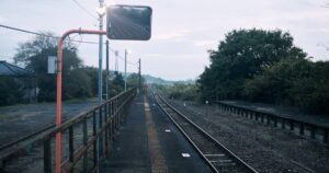 人物のいない地方駅のホームと線路を背景に、昭和鉄道高校の2027年度入試と鉄道科2コースを考える記事サムネイル