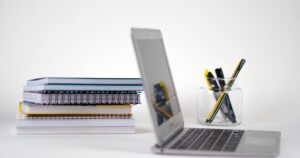 人物のいないノートパソコン・ノート・筆記具の学習机を背景に、帝京長岡高校の2027年度入試と4コースを考えるイメージ