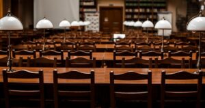 人物のいない大学図書館の閲覧席を背景に、苫小牧東高校の2027年度一般選抜と進路学習を考えるイメージ