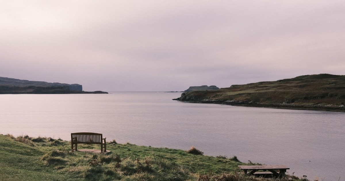 人物のいない穏やかな入り江と草地、木製ベンチを写した横長写真、鳥取商業高校の4類型と2027年度入試を解説する記事のサムネイル