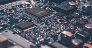 人物のいない工学研究室の電子機器、工具、設計図を背景に、豊田高専の5学科と2027年度入試を考えるイメージ