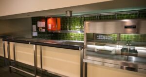 人物のいない明るい業務用厨房を背景に、楊志館高校の調理科を含む4科7コースと2027年度入試準備を考えるイメージ